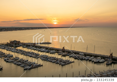 Yacht club top view. The sky in the evening. Water sea parking ships. Sunset sky at seaport of Italian city of Rimini in Summer. 133145339