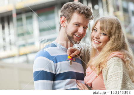 Couple with keys on front of new modern house Couple with keys on front of new modern house 133145398