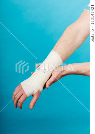 Man with painful bandaged hand. Man with painful bandaged hand. 133145421