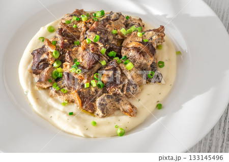 Braised meat and mushroom topping over creamy mashed potato served on white plate Braised meat and mushroom topping over creamy mashed potato served on white plate 133145496