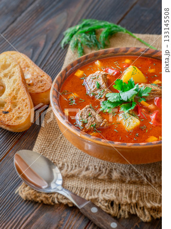 Traditional Bogracs stew garnished with parsley served with toasted bread beside 133145508