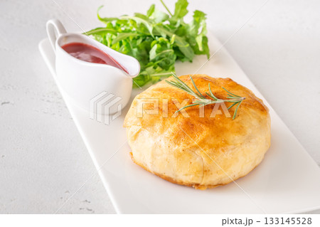 Golden Camembert en Croute with rosemary sprig and deep red cranberry sauce 133145528