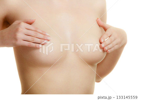 Woman examining her breasts for breast cancer Woman examining her breasts for breast cancer 133145559