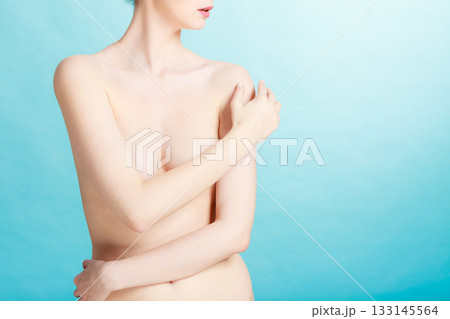 Bare woman covering her breast with hands 133145564
