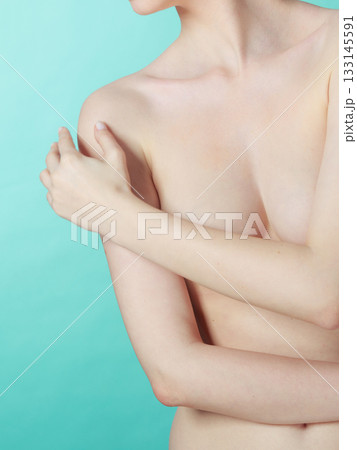 Bare woman covering her breast with hands 133145591