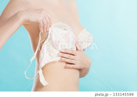 Naked woman dressing up her bra. 133145599