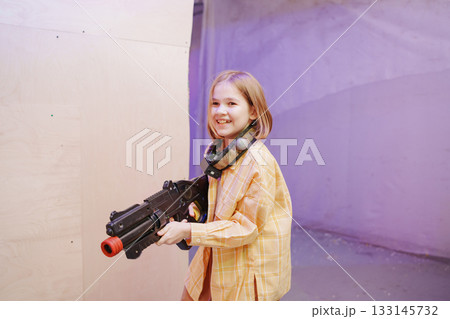 Child plays with toy gun in indoor gaming space 133145732