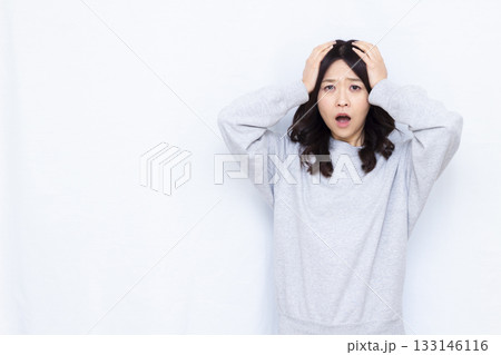 頭を抱えて驚く女性 133146116