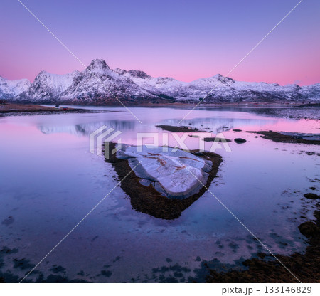 Aerial view of stones, calm water with snow-covered rocks 133146829