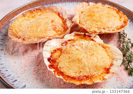 scallop, baked in shells, with cheese and spices, on a plate, homemade, 133147368