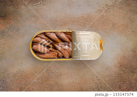 open tin can with sprats, appetizer, on the table, top view, open tin can with sprats, appetizer, on the table, top view, 133147374