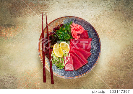 tuna sashimi with daikon and wakame salad, pickled ginger, in a bowl, 133147397