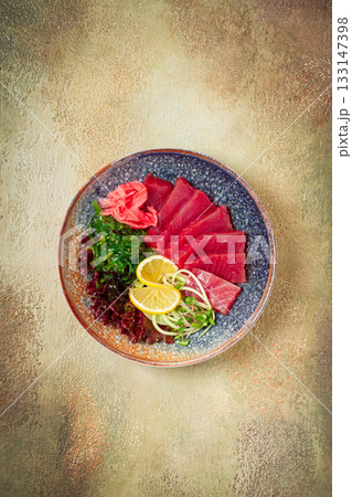 tuna sashimi with daikon and wakame salad, pickled ginger, in a bowl, 133147398