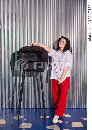 woman leaning on sculpture in studio, contemporary woman poses casually with sculpture background woman leaning on sculpture in studio, contemporary woman poses casually with sculpture background 133147582