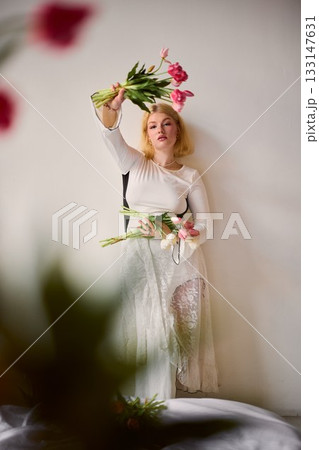 Tranquil female figure in light dress with floral accents 133147631
