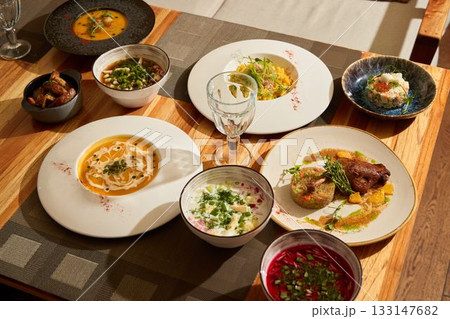 A Gourmet Dinner Spread with an Array of Vibrant Dishes Served on Beautifully Decorative Plates A Gourmet Dinner Spread with an Array of Vibrant Dishes Served on Beautifully Decorative Plates 133147682