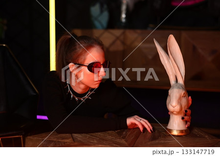woman expertly rehearses magical illusions involving rabbit sculpture under dramatic stage lighting woman expertly rehearses magical illusions involving rabbit sculpture under dramatic stage lighting 133147719