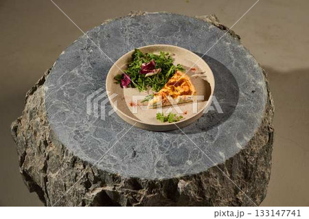 Enjoy a Delicious Quiche Served with Fresh Greens on a Rustic Stone Table Setting Enjoy a Delicious Quiche Served with Fresh Greens on a Rustic Stone Table Setting 133147741