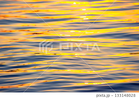 Reflection of the setting sun in a wave of water. Natural background texture 133148028