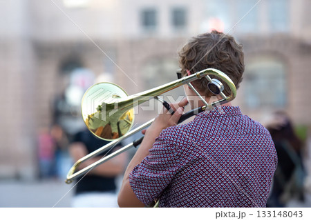 Reflection of the street in the instrument solo trumpet. male musician plays the trombone. 133148043
