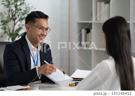 Friendly Insurance Advisor Explaining Options to Client 133148452