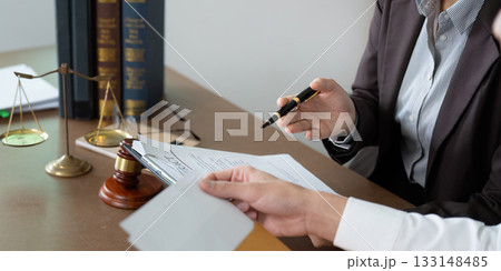 Legal Consultation. Lawyer discussing contract details with a client in an office. Legal Consultation. Lawyer discussing contract details with a client in an office. 133148485
