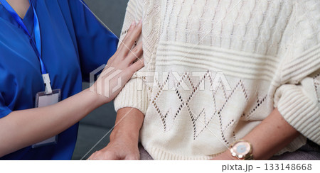 Elderly Support. Nurse providing gentle touch to senior woman, ensuring comfort. 133148668