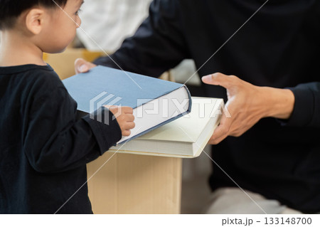 Parent-Child Bonding: Young Boy Helping with Moving Books 133148700
