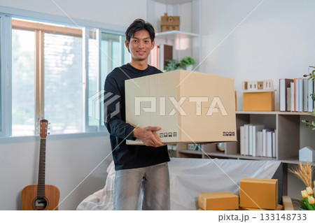 Moving Day. Young man carrying large box in bright living room. Moving Day. Young man carrying large box in bright living room. 133148733