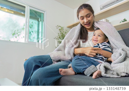 Warm Moments. Mother and son wrapped in a blanket enjoying gaming together. Warm Moments. Mother and son wrapped in a blanket enjoying gaming together. 133148739