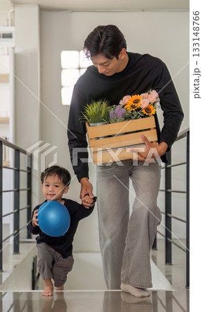 Family Moment: Father and Son Walking with Flowers and Balloon Family Moment: Father and Son Walking with Flowers and Balloon 133148766