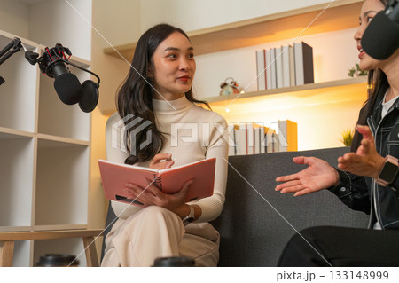 Podcast Recording. Engaging conversation between two women in a creative workspace. Podcast Recording. Engaging conversation between two women in a creative workspace. 133148999