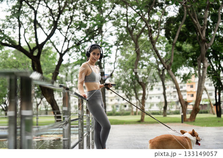 Stylish Woman with Corgi at Park Railing 133149057