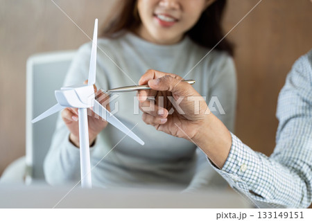 Sustainable Energy Discussion. Team examining a wind turbine model in a collaborative setting. 133149151