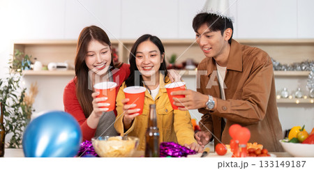 Joyful friends celebrating with drinks at a festive party 133149187