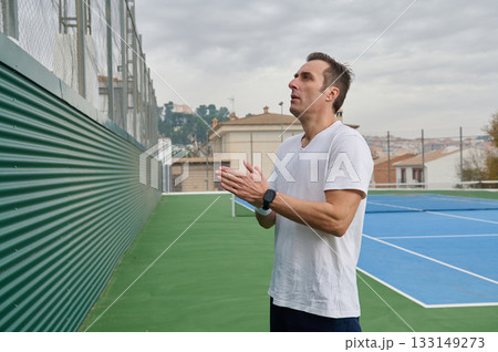 Athletic Man On Outdoor Tennis Court Looking Upward And Clapping Hands 133149273