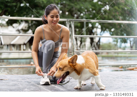 Active Lifestyle. Young Woman Exercising with Corgi in Park 133149331