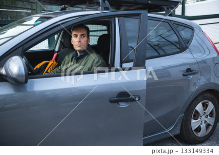 Business Traveler Sitting in Car With Open Door, Luggage, and Roof Rack Business Traveler Sitting in Car With Open Door, Luggage, and Roof Rack 133149334