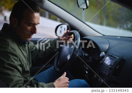 Focused Man Driving Car Interior, Steering Wheel Grip, Calm Mood, Urban Road View Focused Man Driving Car Interior, Steering Wheel Grip, Calm Mood, Urban Road View 133149343