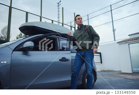 Man With Car Roof Box Ready For Travel In Parking Lot 133149350