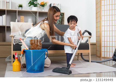 Mother Teaching Child to Vacuum as a Fun Activity Mother Teaching Child to Vacuum as a Fun Activity 133149449