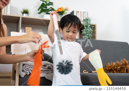 Child Playing with Cleaning Tools During Household Chores Child Playing with Cleaning Tools During Household Chores 133149450