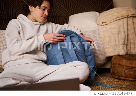 Teen Boy Packing Backpack At Home For School Day - Casual, Relaxed Moment 133149477