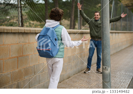 Teenager With Blue Backpack Greets Man On Sidewalk During Friendly Exchange Teenager With Blue Backpack Greets Man On Sidewalk During Friendly Exchange 133149482