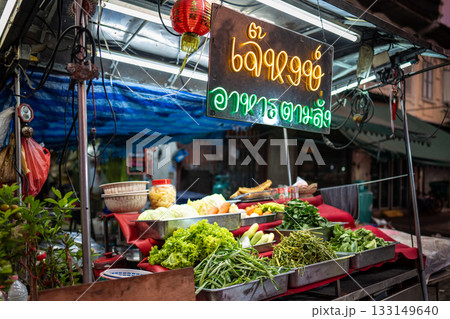 Street food market stall with neon sign and ingredients in trays selling takeaway snacks in Bangkok. Street food market stall with neon sign and ingredients in trays selling takeaway snacks in Bangkok. 133149640