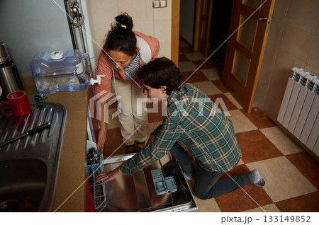 Two Friends Loading Dishwasher In Modern Kitchen For A Cozy Home After Dinner 133149852
