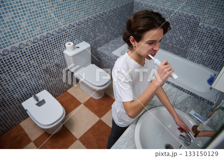 Teenage Boy Brushing Teeth During Morning Bathroom Routine At Home 133150129