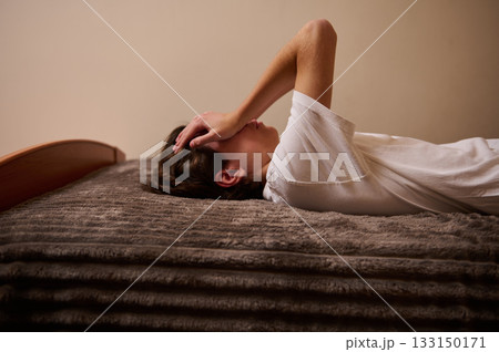 Teenager Lying on Bed Resting Face in Hands, Tired Mood, Bedroom Scene Teenager Lying on Bed Resting Face in Hands, Tired Mood, Bedroom Scene 133150171