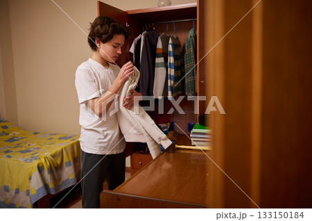 Teen Boy Organizing Clothes In Bedroom Closet For Stock Photo Shoot Casual Morning Routine 133150184