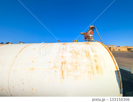 Old storage tank in an industrial area under a clear blue sky during daylight hours Old storage tank in an industrial area under a clear blue sky during daylight hours 133150306